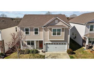 Charming two-story home featuring neutral siding, an attached two-car garage, and a cozy front porch at 1055 Kerr St, Burlington, NC 27215