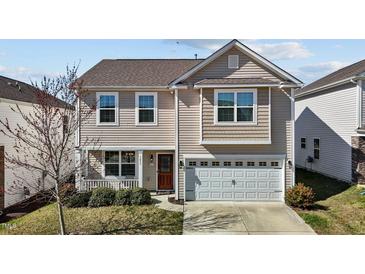 Charming two-story home featuring a front porch, attached garage, and neutral-toned siding at 1055 Kerr St, Burlington, NC 27215