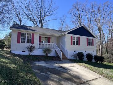 Charming one-story home featuring a quaint front porch and driveway at 1104 Thelonious Dr, Raleigh, NC 27610