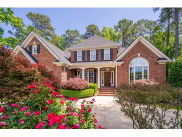 Charming two-story brick home featuring a manicured lawn and beautiful landscaping at 112 Trellingwood Dr, Morrisville, NC 27560