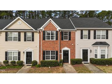 Charming townhomes featuring varied facades, dark shutters, and manicured landscaping at 116 Anterbury Dr, Apex, NC 27502