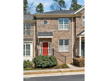 Charming brick townhome with a bright red door and manicured landscaping at 138 Tressel Way, Durham, NC 27707