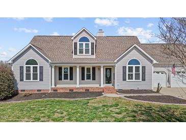 Charming home featuring a welcoming front porch, well-manicured lawn, and classic architectural details at 1408 Harvey Johnson Rd, Raleigh, NC 27603