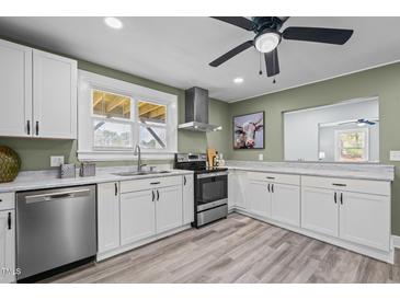 Bright kitchen features stainless steel appliances, white cabinets, and modern countertops at 1855 W West River Rd, Franklinton, NC 27525