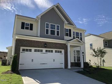 Charming two-story home featuring a brick and siding exterior and an attached two-car garage at 49 W Copenhaver Dr, Clayton, NC 27527
