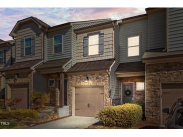 Charming townhome with stone accents, attached garage, and professionally landscaped yard at 517 Aronia Dr, Hillsborough, NC 27278
