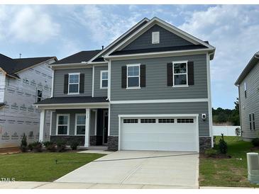 Beautiful two-story home featuring a spacious two-car garage and neutral gray siding at 712 Swim Cave Ln, Wendell, NC 27591