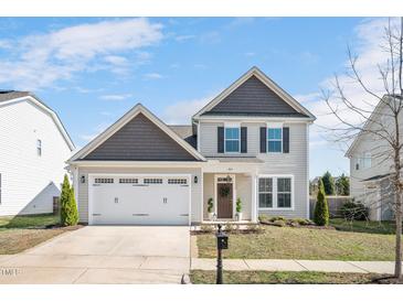 Charming two-story home featuring a two-car garage, neutral siding, and a welcoming front door at 724 Summer Music Ln, Raleigh, NC 27603