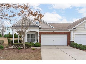 Charming townhome featuring a two-car garage, brick accents, and a well-manicured front yard at 734 Hornchurch Loop, Cary, NC 27519