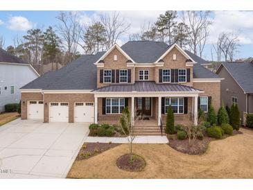 Stunning brick home with a three-car garage and mature landscaping at 832 Mountain Vista Ln, Cary, NC 27519