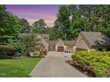 Charming home featuring a well-manicured lawn, mature trees, and a private driveway leading to a two-car garage at 12117 Cliffside Cir, Raleigh, NC 27614