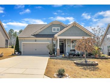 Charming single-Gathering home with a well-maintained lawn, attached garage, and inviting curb appeal on a sunny day at 123 Carbone Ln, Clayton, NC 27527