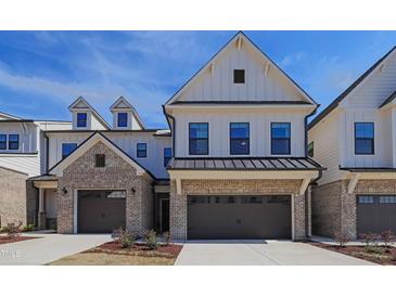 Beautiful townhome featuring a two-car garage and a combination of white siding and brick exterior at 163 Periwinkle Pl, Clayton, NC 27527