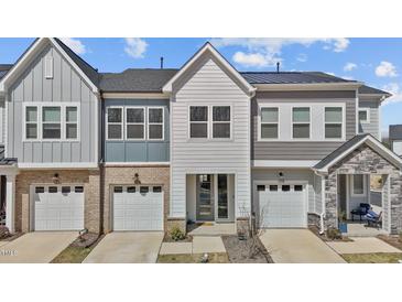 Beautiful townhome featuring a two-car garage, manicured lawn, and modern architectural details at 175 Norwell Ln, Pittsboro, NC 27312