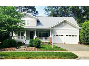 Charming two-story home boasts a welcoming front porch, attached two-car garage and beautifully landscaped yard at 2429 Falls River Ave, Raleigh, NC 27614