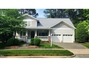 Charming home with manicured lawn, covered porch, and two-car garage at 2429 Falls River Ave, Raleigh, NC 27614