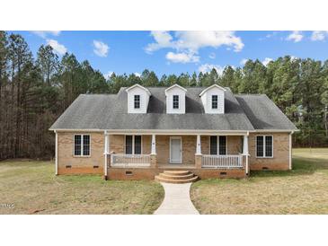 Charming brick home with three dormer windows, covered porch, and beautiful landscaping at 2505 Egypt Mountain Rd, Kittrell, NC 27544
