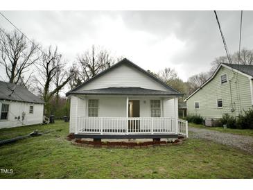Charming white bungalow with a cozy front porch and a well-maintained lawn at 423 E Rockspring St, Henderson, NC 27536
