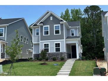 Charming two-story home with stone accents and well-maintained landscaping and covered front entryway at 5648 Cayden Cove Dr, Wendell, NC 27591