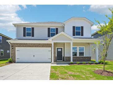 Two-story home featuring a spacious two car garage and a welcoming front porch at 571 White Birch Ln, Angier, NC 27501