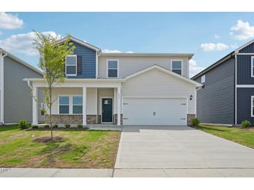 Charming two-story home featuring a covered front porch and a two-car garage at 591 White Birch Ln, Angier, NC 27501