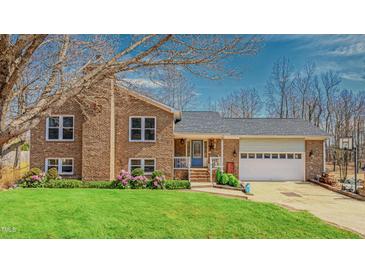 Charming brick home featuring a well-manicured lawn and an attached two car garage at 6089 Joe Trail Ct, Mebane, NC 27302
