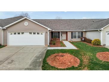 Charming single-story home with a well-maintained lawn, attached garage, and inviting front entrance at 653 Huntingdon St, Elon, NC 27244