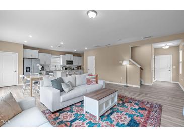 Bright living room featuring an open layout with a modern white sofa and a colorful rug at 656 Dallas Rose Dr, Wendell, NC 27591