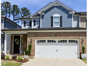 Charming two-story home featuring a brick facade, two-car garage, and well-maintained landscaping at 938 Haybeck Ln, Apex, NC 27523