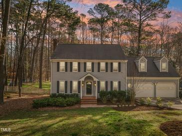 Charming two-story home with black shutters, gray siding, mature trees, and a well-manicured lawn at 1113 Harvest Mill Ct, Raleigh, NC 27610