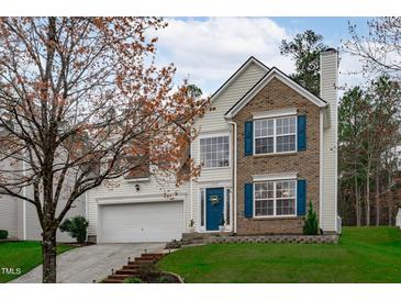 Charming two-story home with brick accents, blue shutters, manicured lawn and a two car garage at 117 Talley Ridge Dr, Holly Springs, NC 27540