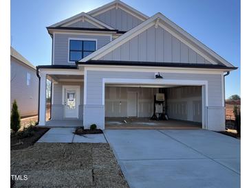 Charming two-story home with a two-car garage, inviting front door, and manicured lawn at 1511 Malcus Ct # 64, Fuquay Varina, NC 27526