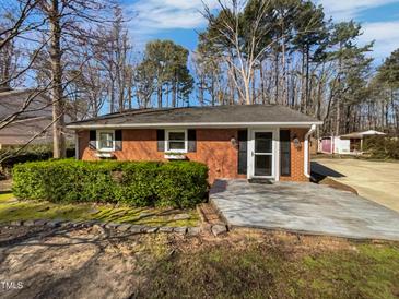 Brick single-story home with a trimmed front hedge, shutters, and a light-colored front porch at 317 Gary St, Raleigh, NC 27606