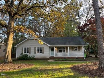 Charming single-story home featuring a cozy front porch and well-manicured lawn surrounded by mature trees at 3329 Bearskin Ct, Raleigh, NC 27606