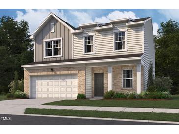 Charming two-story home featuring a brick and siding facade and an attached garage at 73 Club Rd, Louisburg, NC 27549