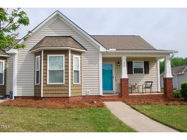 Charming single-story home featuring a covered front porch, bay window, and well-manicured lawn at 75 E Moss Creek Dr, Clayton, NC 27520