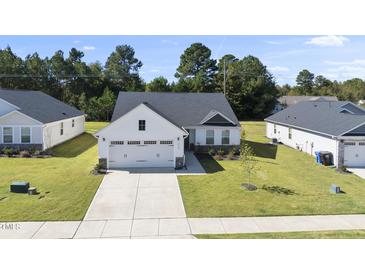 Charming single-story home with a well-manicured lawn and two-car garage at 8710 Kenridge Ln, Fuquay Varina, NC 27526