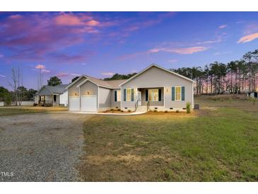 Charming single-story home featuring a two-car garage and beautiful landscaping at 1076 Nc 55, Coats, NC 27521