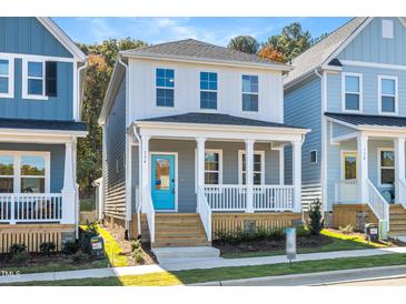 Charming two-story home featuring a welcoming front porch, complemented by a vibrant blue door and neat landscaping at 113 Weavers Grove Dr, Chapel Hill, NC 27514