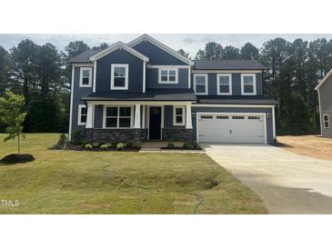 Beautiful two-story home with blue siding, stone accents, and a spacious two-car garage at 114 Tee Time Ter, Benson, NC 27504