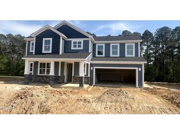Beautiful two-story home with a dark blue exterior, a two-car garage, and stone accents on the front facade at 114 Tee Time Ter, Benson, NC 27504
