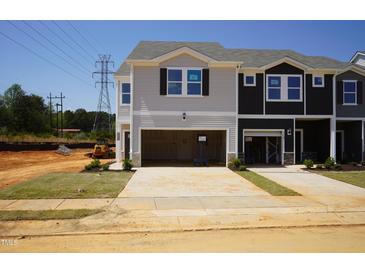 Charming new construction townhomes featuring attached garages and craftsman-style design with black and gray accents at 1165 Abbott St, Mebane, NC 27302