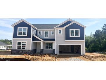 New two-story home featuring blue and gray siding, a stone foundation, and an attached two-car garage at 245 Golfview Ave, Benson, NC 27504