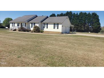Charming single-story home with attached garage, well-manicured lawn, and mature trees at 3226 Powhatan Rd, Clayton, NC 27527