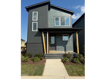 Two-story home with modern design, gray siding, and a covered front porch with wooden support beams at 50 Rainfall Dr, Pittsboro, NC 27312