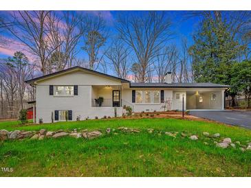 Charming home featuring a black roof, white exterior, manicured lawn, and inviting curb appeal at 605 Canterbury Rd, Sanford, NC 27330