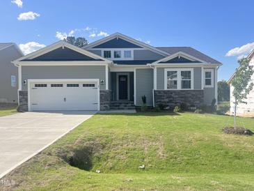 Charming single-Gathering home featuring a two-car garage and lush lawn at 63 Tee Time Ter, Benson, NC 27504