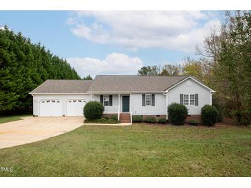 Charming one-story home with a two-car garage and well-manicured lawn at 7329 Blannie Farms, Willow Springs, NC 27592