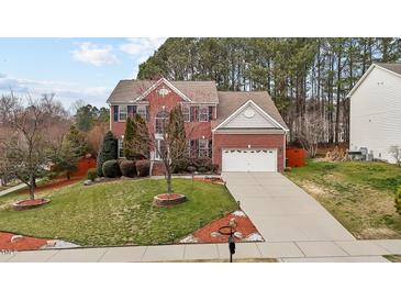 Charming two-story brick home with a well-manicured lawn and attached two-car garage at 1046 Upchurch Farm Ln, Cary, NC 27519