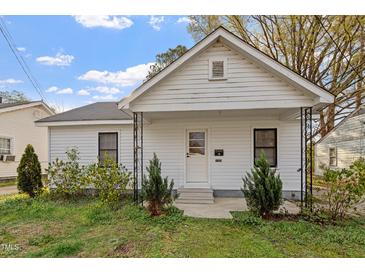 Charming one-story home featuring a gable roof, two windows, and a small porch supported by decorative metal posts at 1103 Gaston St, Smithfield, NC 27577